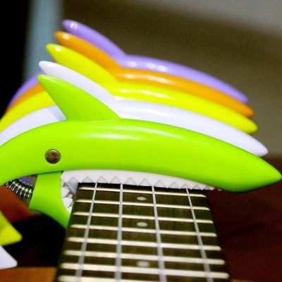 vue face Capodastre en Plastique en forme de requin - 5 couleurs fluo