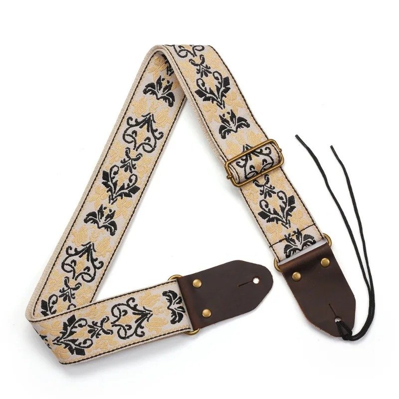 Sangle guitare jacquard crème à arabesques noires et fleurs dorées avec embouts en cuir et lacet