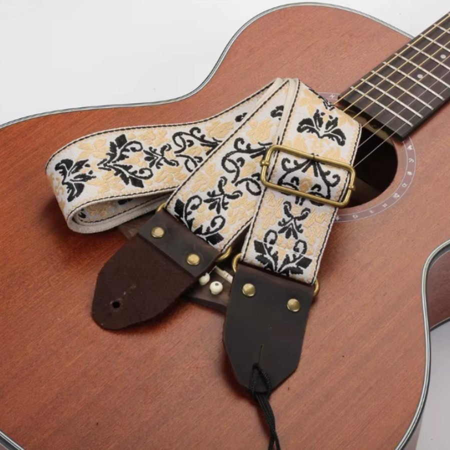 Sangle guitare jacquard vintage Arabesques Impériales posée sur une guitare acoustique