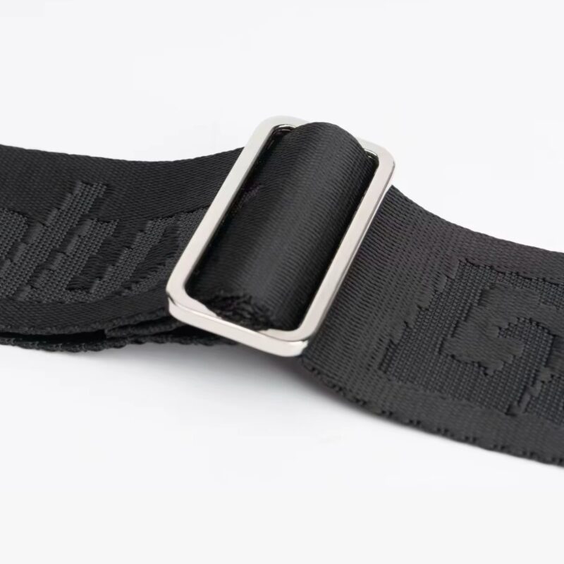 Gros plan sur la boucle de réglage métallique de la sangle Power Grip noire en nylon tissé